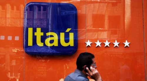 A man walks past an Itau Unibanco logo in Rio de Janeiro, Brazil